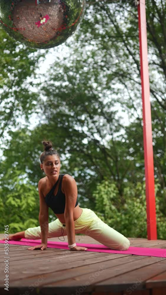 Young woman is practising yoga on a wooden podium Young woman is practising yoga on a wooden podium