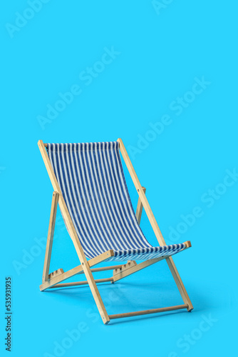 Fotografering Beach deck chair on light blue background