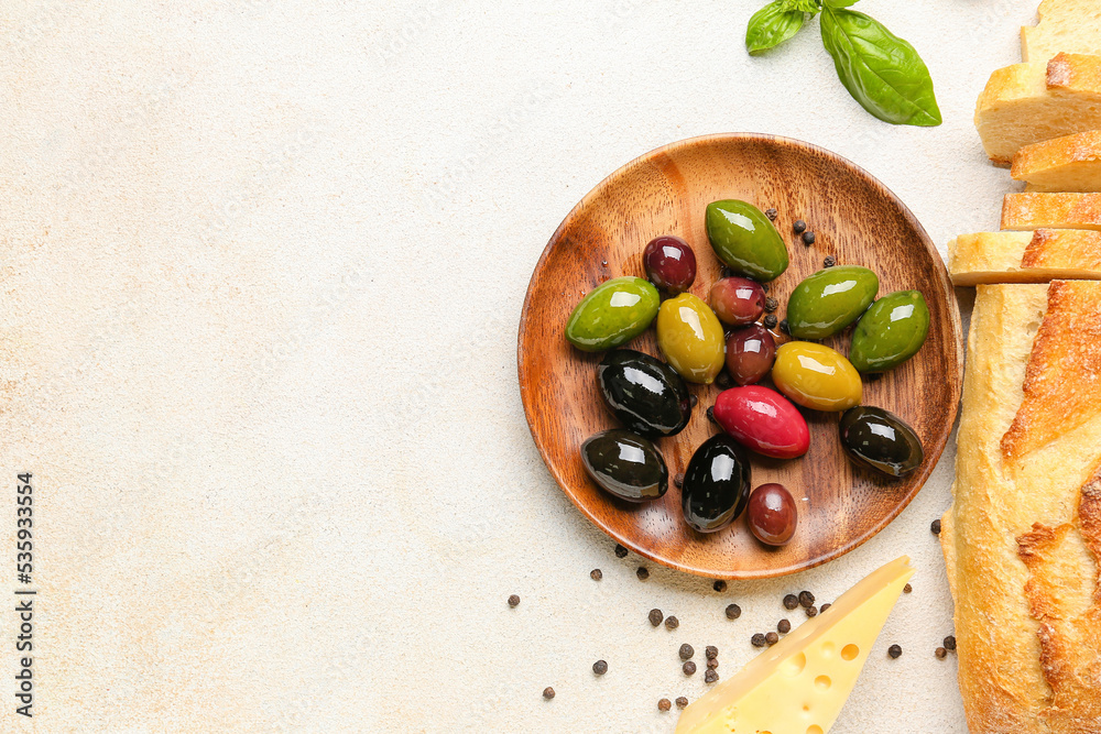 Plate of tasty olives and bread on light background Plate of tasty olives and bread on light background
