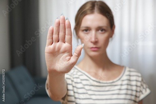 Serious worried young woman making hand stop gesture expressing fighting for equal rights against domestic violence, abuse, discrimination, bullying, sexual or racial discrimination. photo