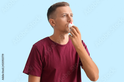 Young man wiping nosebleed ...