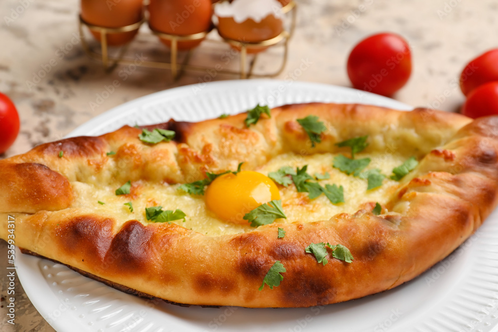 Plate of tasty Ajarian khachapuri on table, closeup Plate of tasty Ajarian khachapuri on table, closeup