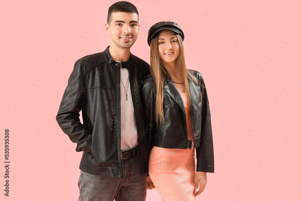 Fashionable young couple in autumn clothes on pink background Fashionable young couple in autumn clothes on pink background