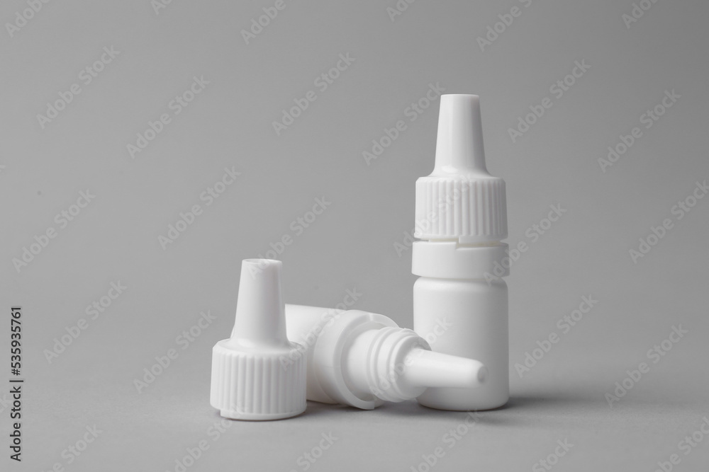 Bottles of medical drops on grey background Bottles of medical drops on grey background