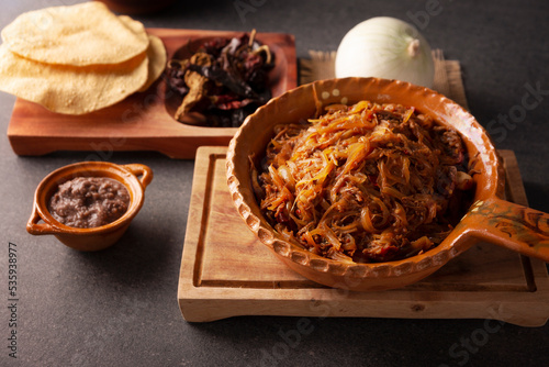 Tinga de Res. Typical Mexican dish prepared mainly with shredded beef, onion and dried chilies. It is customary to serve it on corn tortilla tostadas or tacos. photo
