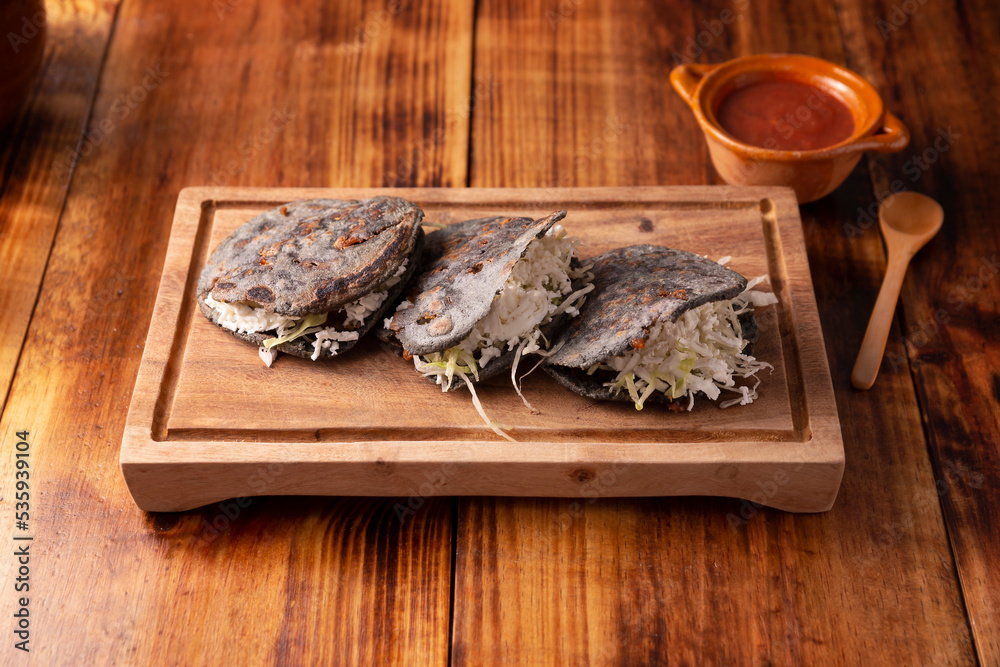 Gordita de Chicharron. Blue Cornmeal dough stuffed with chicharron prensado. Traditional Mexican appetizer commonly accompanied by cilantro, onion and hot sauce. Gordita de Chicharron. Blue Cornmeal dough stuffed with chicharron prensado. Traditional Mexican appetizer commonly accompanied by cilantro, onion and hot sauce.