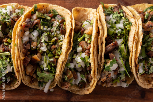Tacos de Suadero. Fried meat in a corn tortilla. Street food from CDMX, Mexico, traditionally accompanied with cilantro, onion and spicy red sauce photo