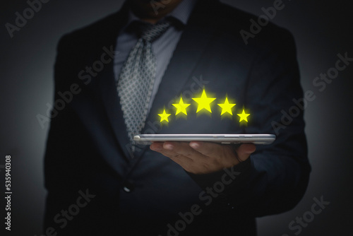 Service satisfaction rating concept. Business people using tablet give the highest rating of five stars. opinion poll answering the questionnaire Service Rating.....