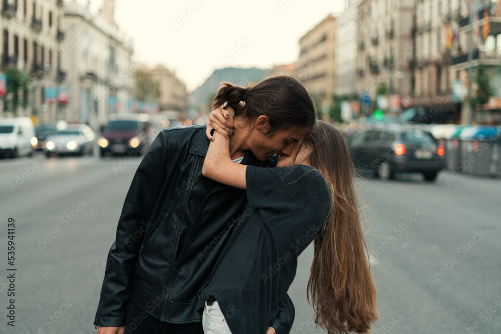 Edgy couple kissing each other in the street