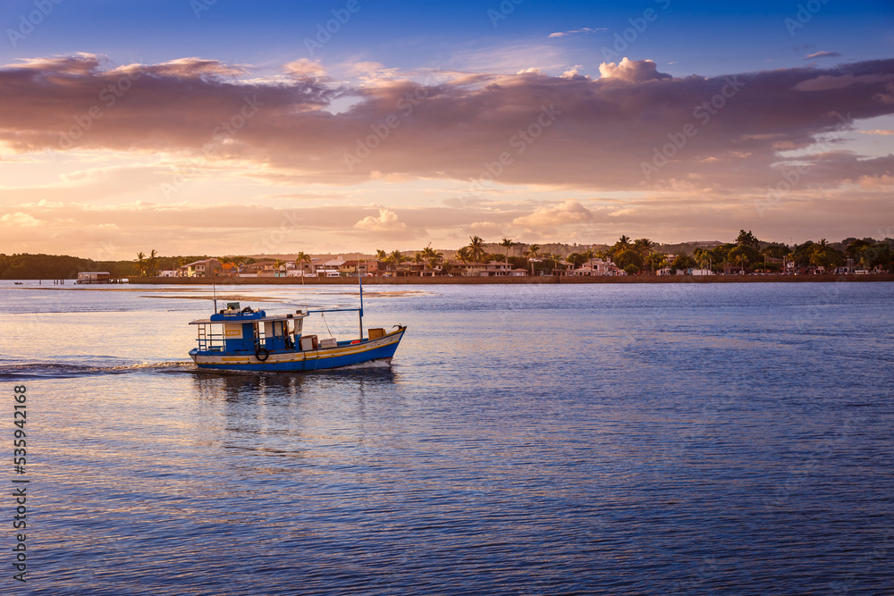 Idyllic Beach at sunset with palm trees and trawler boat in Porto Seguro , BAHIA