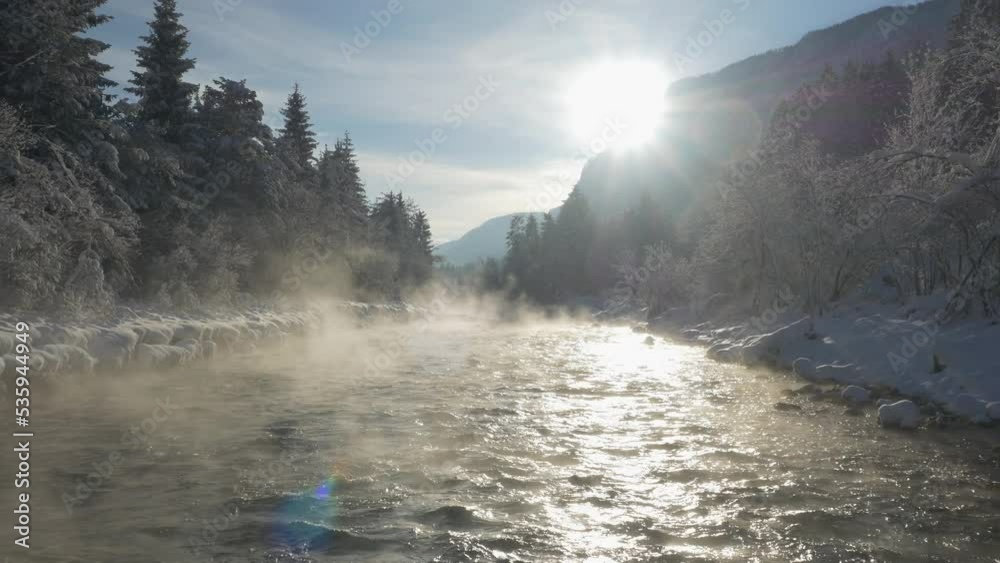 AERIAL: Morning mist lifting above flowing Sava River on a cold snowy morning. White fairy tale at picturesque Sava Valley after freshly fallen snow. Magnificent wintery moment in scenic alpine world. AERIAL: Morning mist lifting above flowing Sava River on a cold snowy morning. White fairy tale at picturesque Sava Valley after freshly fallen snow. Magnificent wintery moment in scenic alpine world.