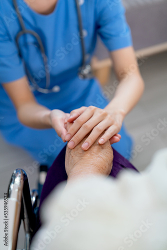 Close up hands of nurse or doctor hold senior woman hands who sit on wheelchair with concept of take care and support elderly people in clinic or hospital center.