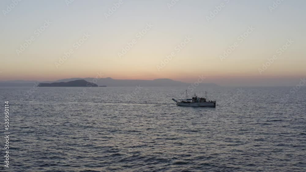Aerial - Large tourist boat cruising in Chania, Greece at dusk Aerial - Large tourist boat cruising in Chania, Greece at dusk
