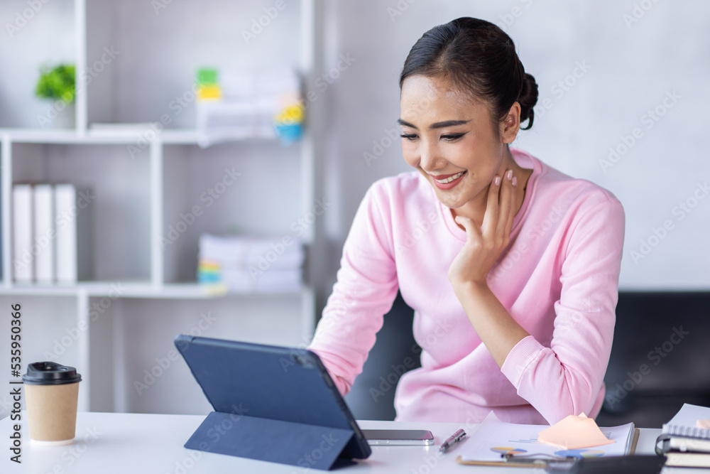 Asian Woman using digital tablet while sitting at home workplace, Asian Female designer sketching on a graphic tablet while working at home. Asian Woman using digital tablet while sitting at home workplace, Asian Female designer sketching on a graphic tablet while working at home.