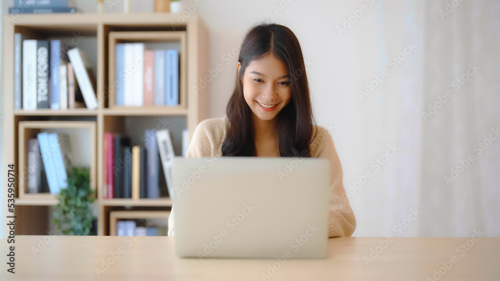 Young asian woman working at home. Female using computer laptop on desk at house Young asian woman working at home. Female using computer laptop on desk at house