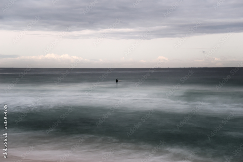 Lone surfer in the water long exposure