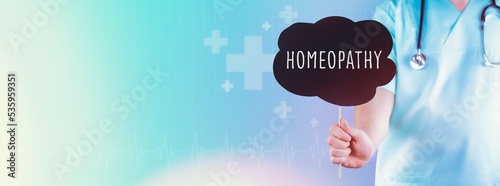 Homeopathy. Doctor holding sign. Text is in speech bubble. Blue background with icons photo