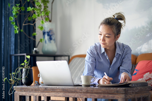 Valokuva mature asian woman working from home using notebook computer