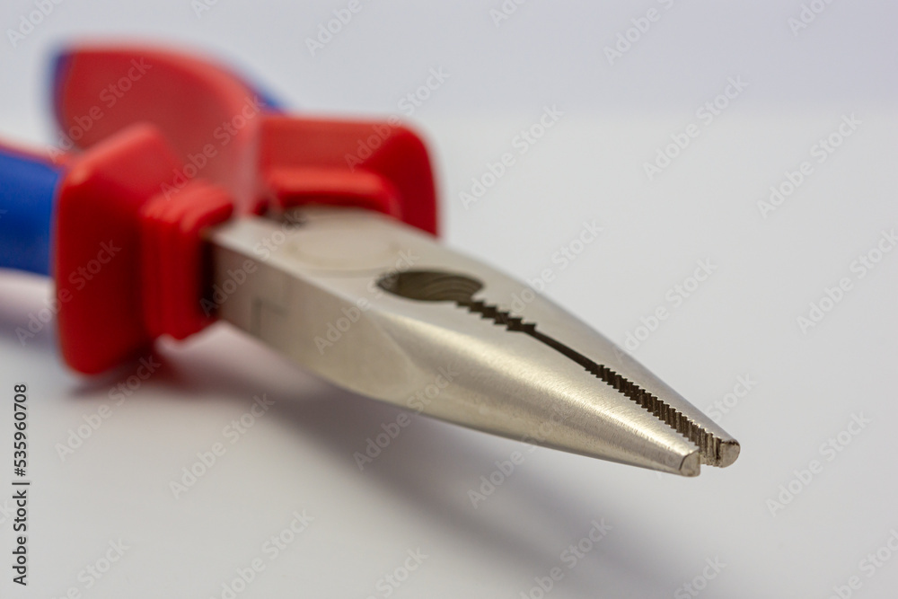 Hand tools, needle-nose pliers, red and blue on a white background.