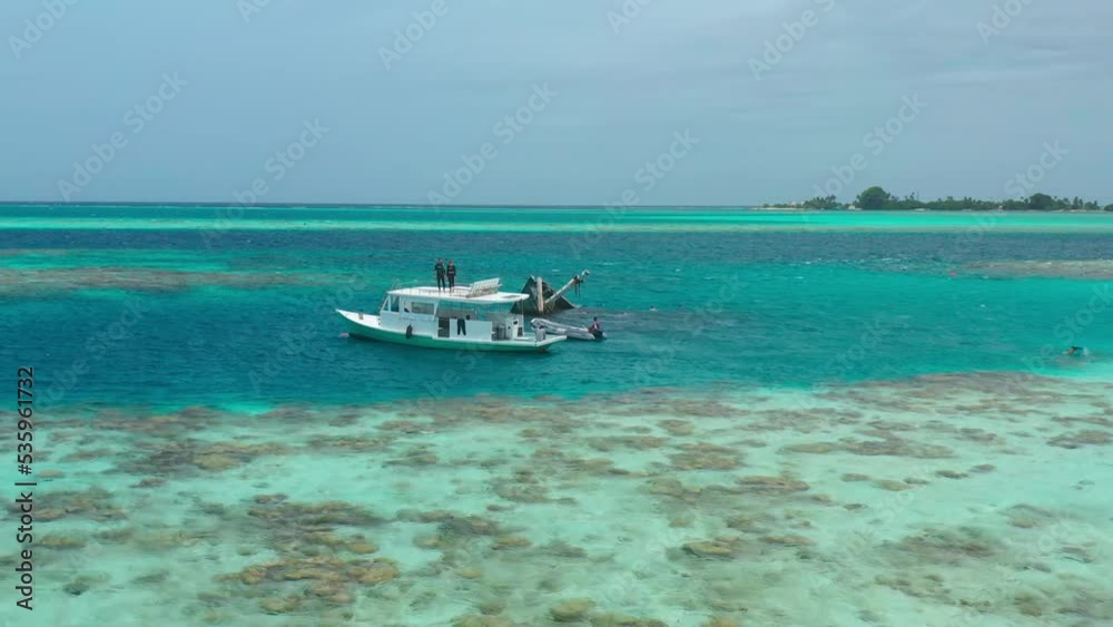 Aerial view on boats with tourists near on Shipwreck in Vaavu Atoll near Keyodhoo Island, Maldives. Aerial view on boats with tourists near on Shipwreck in Vaavu Atoll near Keyodhoo Island, Maldives.