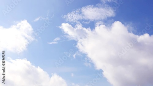 moving white clouds on blue sky.