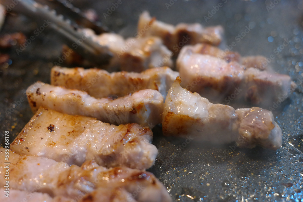 Grilling pork belly on an iron plate Grilling pork belly on an iron plate