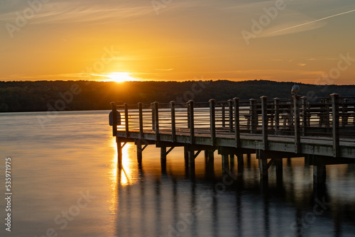 Sunset photo of the Myers Point pier at Myers Park in Lansing NY, Tompkins County. The dock, pier, is situated on the shore eastern shore of Cayuga Lake, near Ithaca New York. 