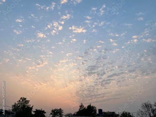 Sunset sky with yellow and orange tint and small clouds