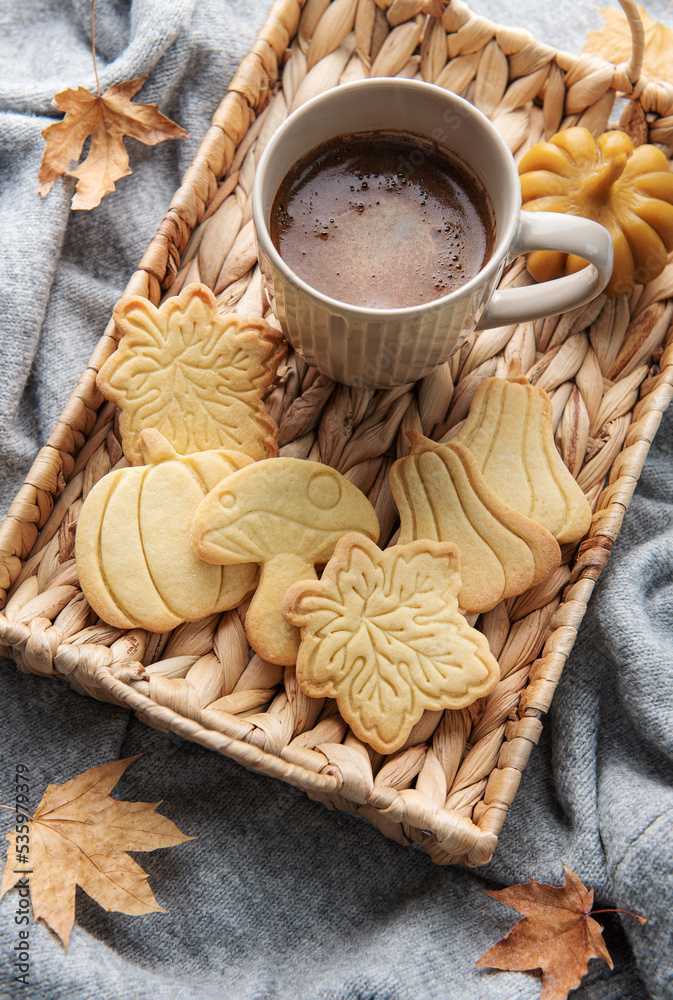 Cup of coffee, cookies on tray, yellow leaves.