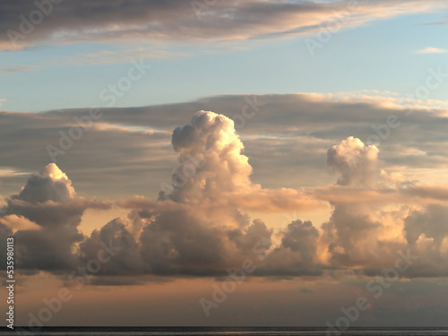 Autumn clouds above the sea. Clouds with pastel colors.