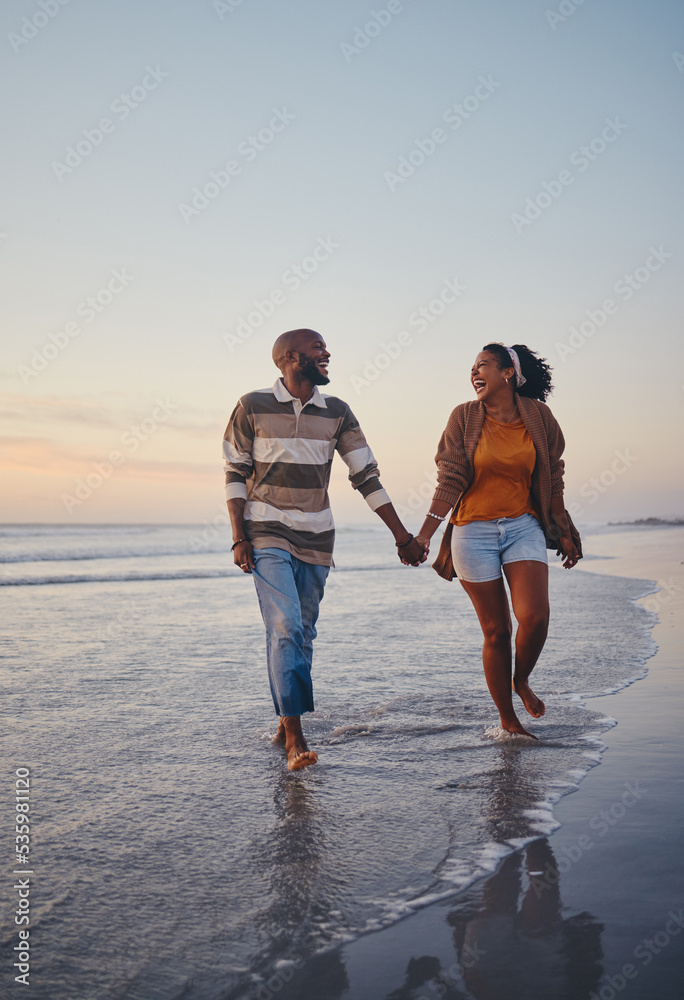 Travel, beach and couple walking in the sea, laughing and bonding on an ocean trip. Freedom, love and romance with black woman and man enjoy conversation and funny joke while holding hands in water - obrazy, fototapety, plakaty 