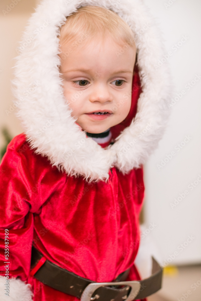 Little cute boy dressed as Santa Claus in a room decorated for Christmas. Christmas and children
Little cute boy dressed as Santa Claus in a room decorated for Christmas. Christmas and children