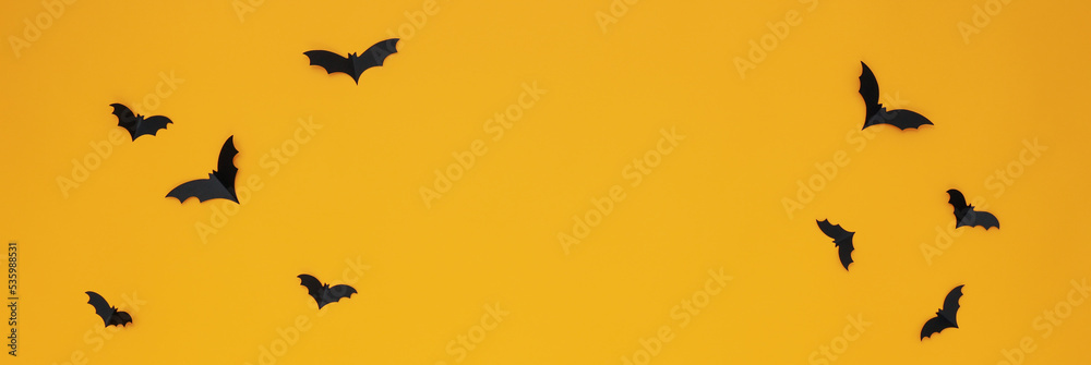 Concept of Halloween, paper bats on yellow background