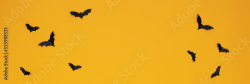 Concept of Halloween, paper bats on yellow background