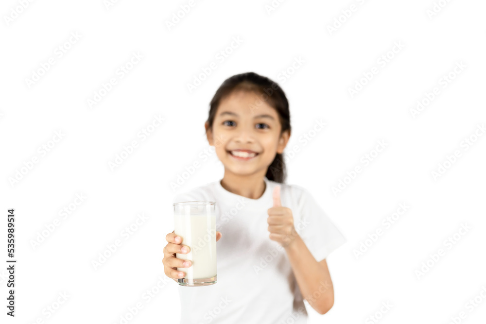 A young Asian girl wear a white T-shirt is smiling. His right hand holds a glass of milk and his left-hand thumbs up with clipping path. A young Asian girl wear a white T-shirt is smiling. His right hand holds a glass of milk and his left-hand thumbs up with clipping path.