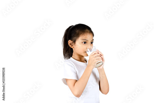 Young Asian girl wear white t-shirt and drinking milk from a glass with clipping path.