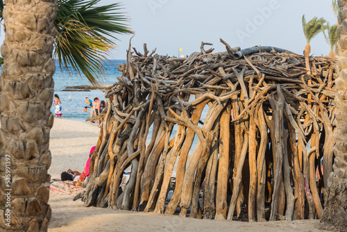 hut made of many driftwood at the beach near the sea