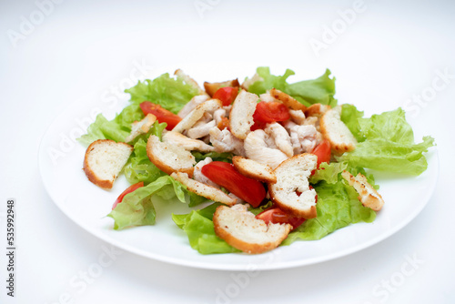 Caesar salad in a plate on a white background