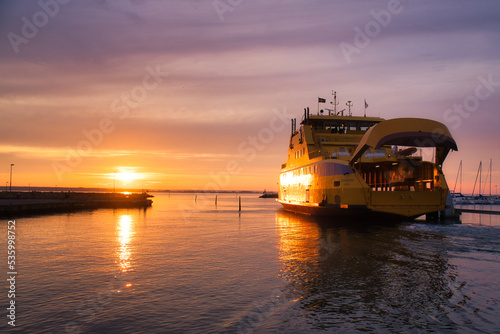 Ferry leaving harbor to Visingsoe island on Vaettern lake for sunset. Lighthouse