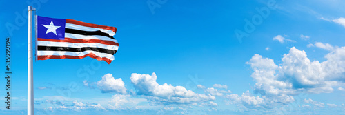 Maranhão - state of Brazil, flag waving on a blue sky in beautiful clouds - Horizontal banner