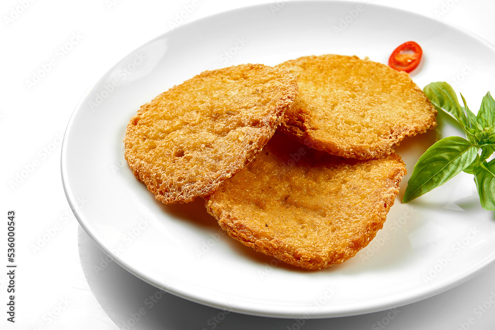 Potato draniki in a white plate on a white background. Close-up, selective focus.