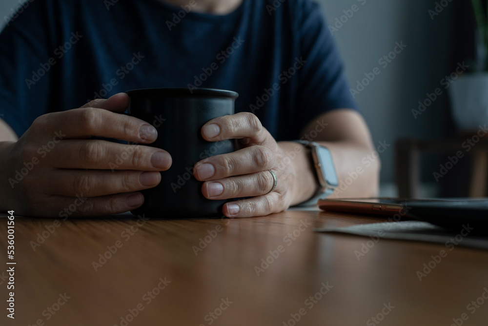 İn female hands a black porridge with coffee sitting at the table İn female hands a black porridge with coffee sitting at the table