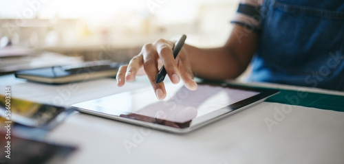 Hand, tablet and design with a woman small business owner working on the internet in her creative startup. Tech, zoom and online with a female designer or entrepreneur at work in her studio closeup