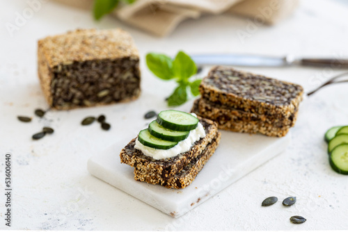 Whole grain Bread without flour creme cheese on a whie board with seeds and tomatoes. High quality photo