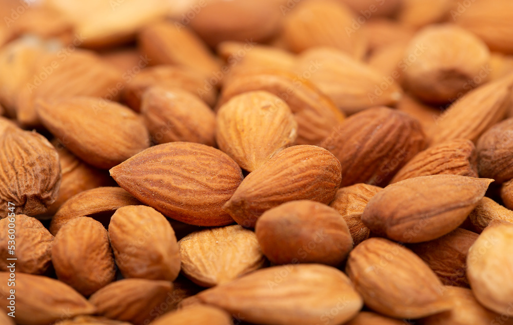 Apricot kernels peeled close-up as a background. Apricot grains heap isolated on white background. Apricot kernels peeled close-up as a background. Apricot grains heap isolated on white background.