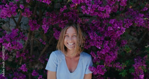 Wallpaper Mural Handheld zoom out shot of authentic happy and laughing young woman with bright natural smile. Attractive and cute full of emotion and happiness woman in flowers and colors Torontodigital.ca