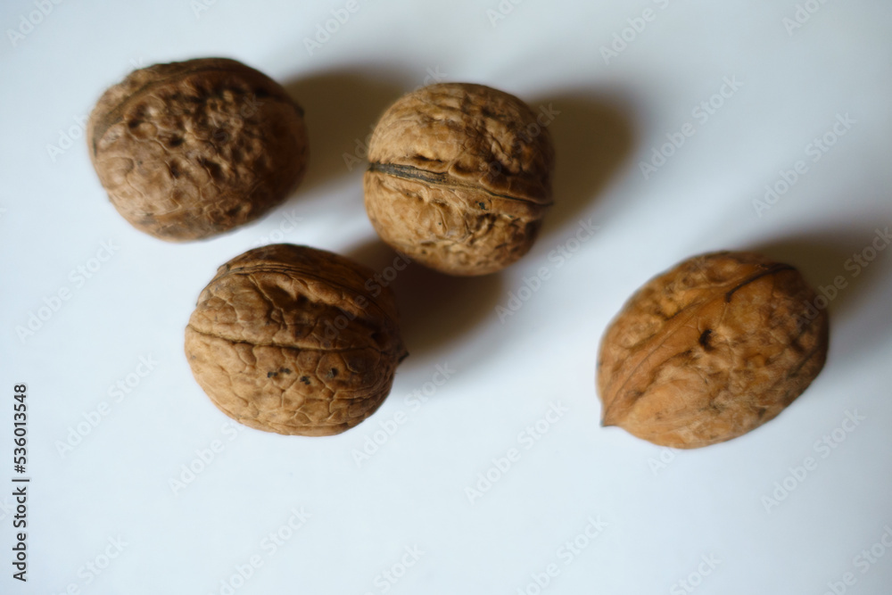 Close view of four ripe brown rounded wrinkly fruits of Persian walnut Close view of four ripe brown rounded wrinkly fruits of Persian walnut