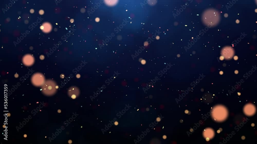 abstract background of the new year festival celebration slow moving particles and confetti on dark blue background.