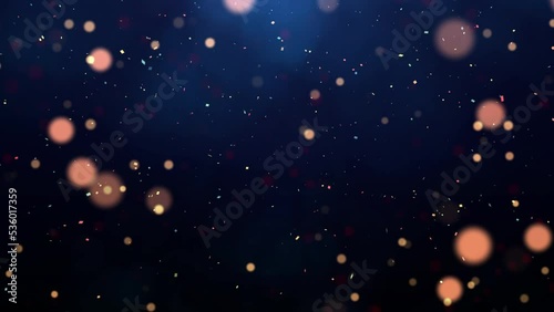 abstract background of the new year festival celebration slow moving particles and confetti on dark blue background.