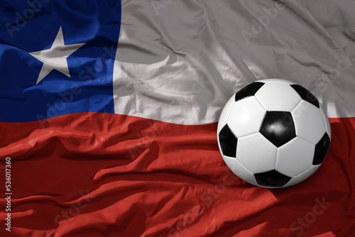 vintage football ball on the waveing national flag of chile background. 3D illustration